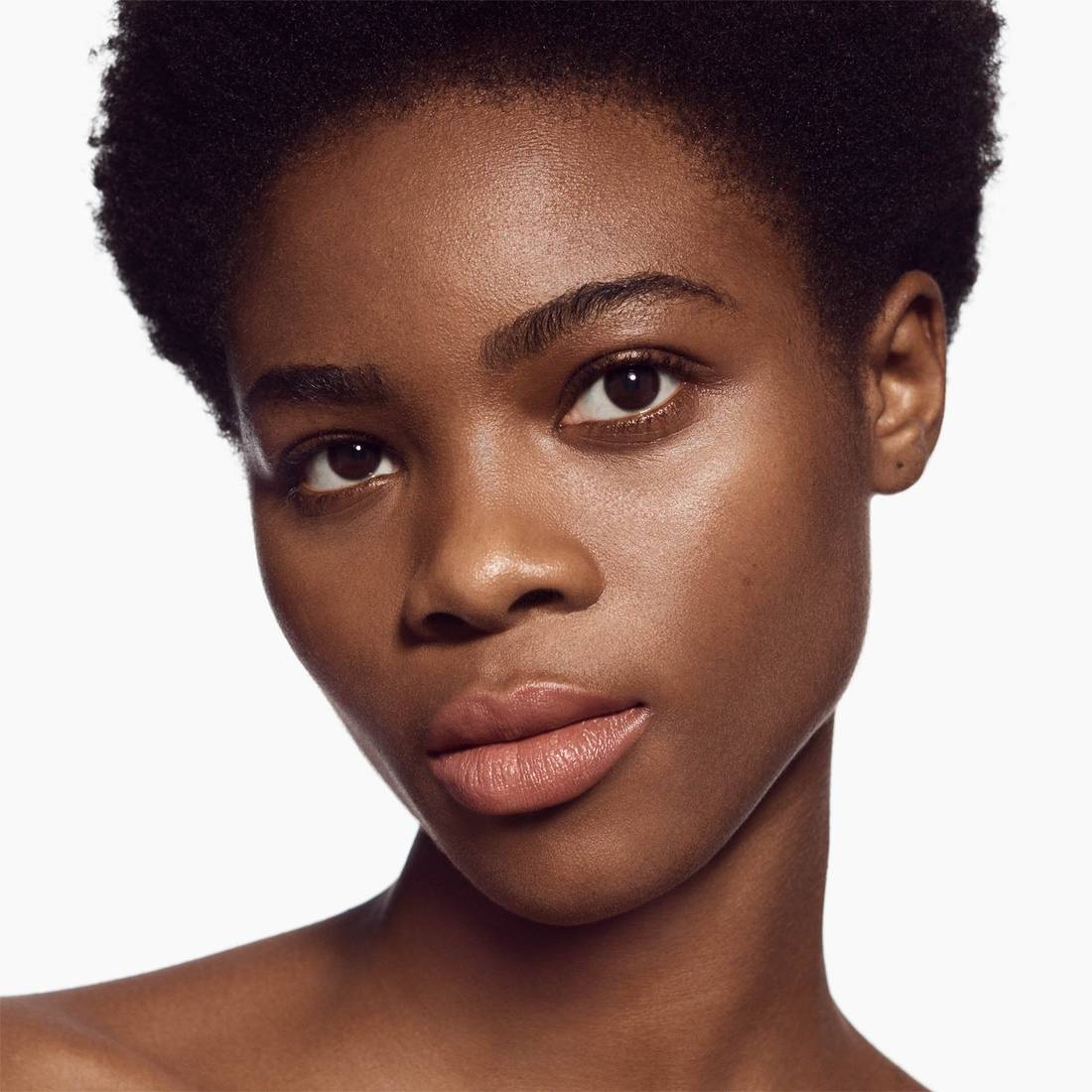 Image of deep skin tone model wearing the Satin Lip Color Rich Refillable Lipstick in shade Besotted 1