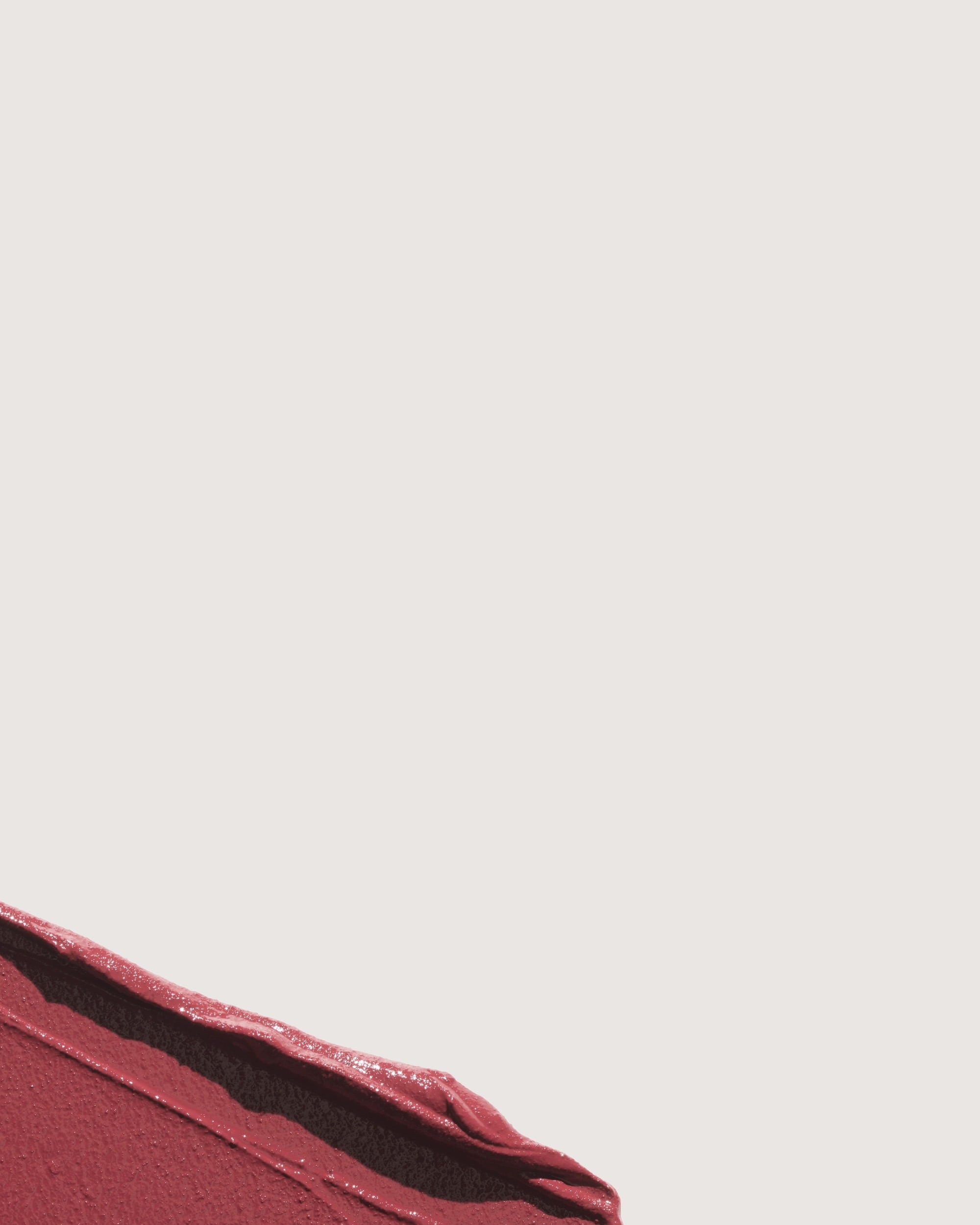 Background image of a formula swatch showcase the Rose Inc Lip Sculpt Amplifying Lip Color's smooth texture. 